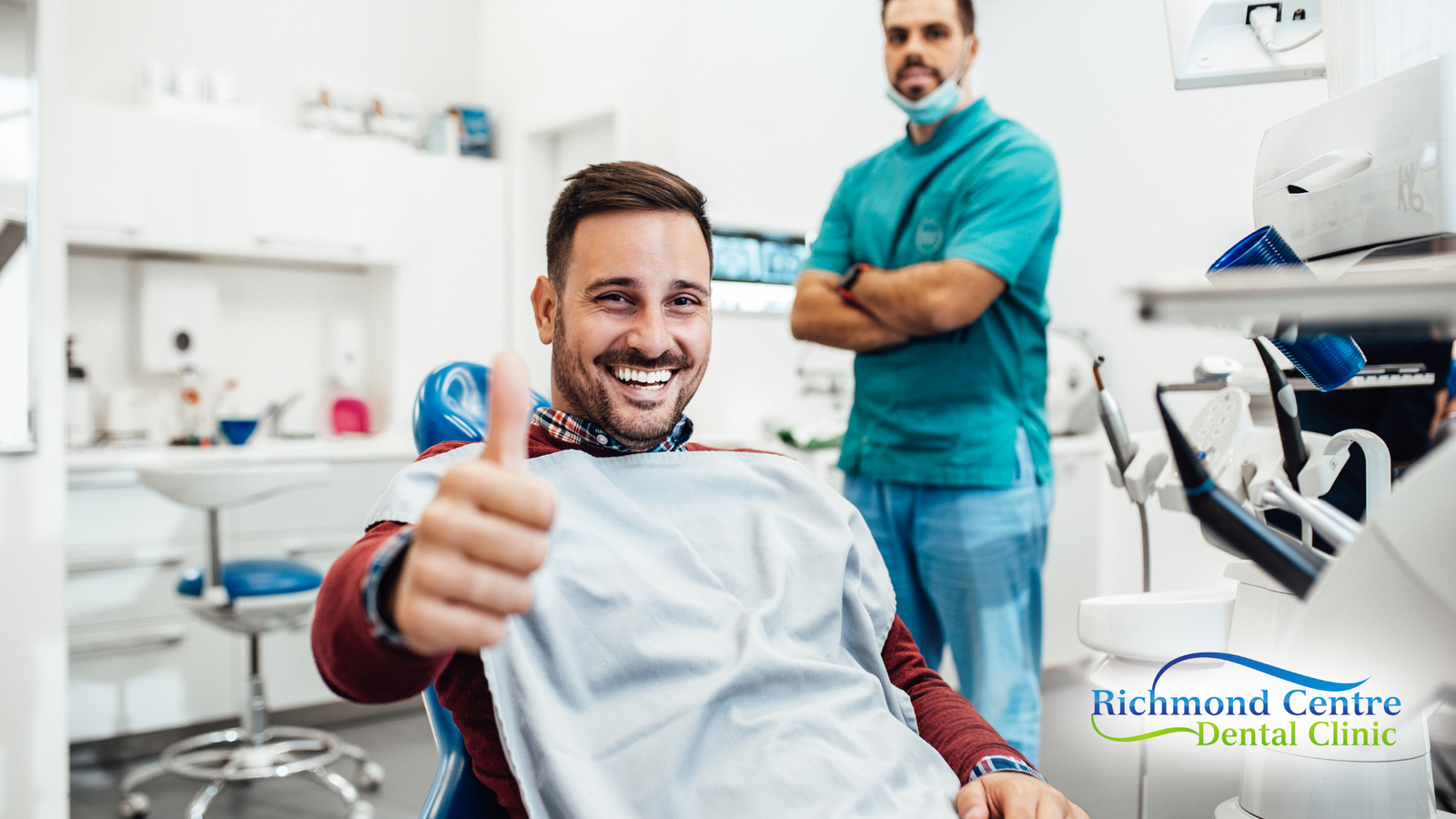 A man is giving a thumbs up while sitting in a dental chair.